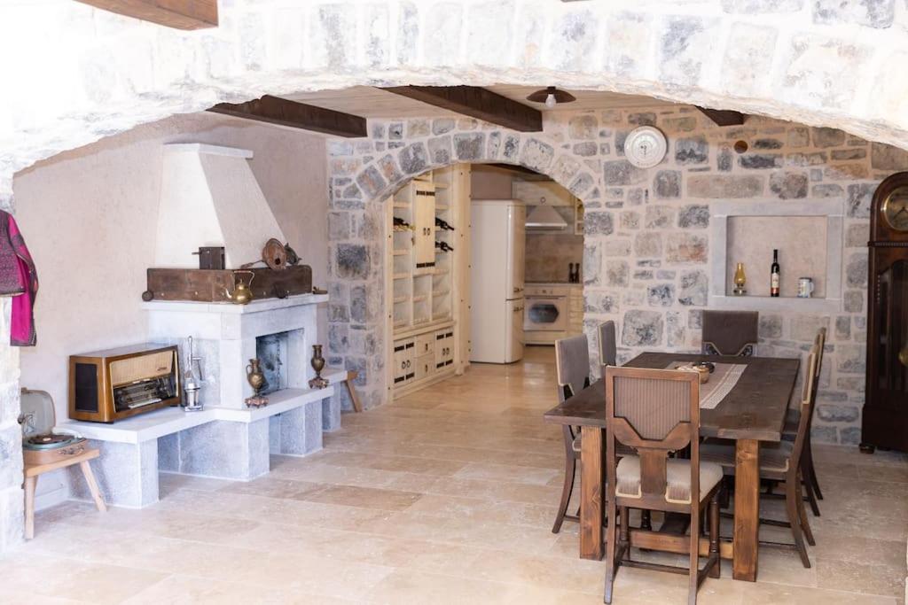 Open-plan stone living and dining area with wine display